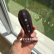 BYD Key fob cover held by a hand with a window and grass outside