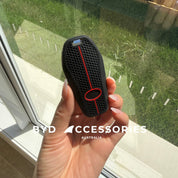 Hand holding a black and red car key fob cover with 'BYD Accessories Australia' branding.