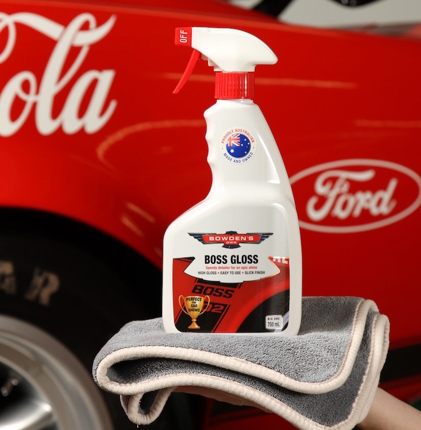 Bowser's Boss Gloss car care product on a gray towel with a red Ford vehicle in the background